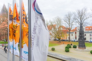 orange-day-20241125-DSC02193-jm-300pdi-srgb-3000xnn © Jan Meßerschmidt Flaggen zum Orange Day vor dem Hauptgebäude der Universität mit Blick auf das Rubenowdenkmal