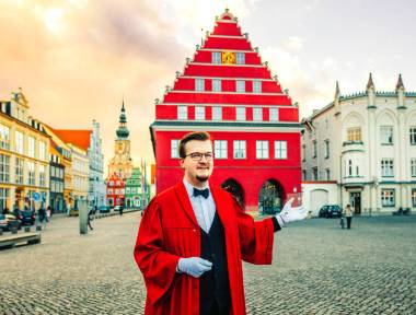 Im Talar gewandeter Stadtführer vor dem Rathaus - © Wally Pruß Im Talar gewandeter Stadtführer vor dem Rathaus