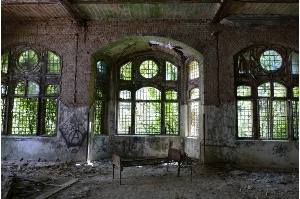 Blick auf ein altes Bettgestellt, das in einem Raum in den verlassenen Beelitz-Heilstätten steht