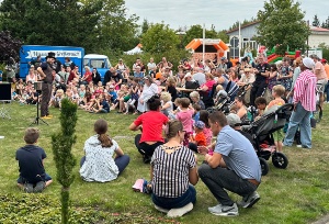 Kinder und Erwachsene schauen einem Clown zu