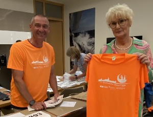 Organisator Peer Kopelmann und Schulleiterin der Kollwitz-GS Ute Prochnow präsentieren ein Shirt bei der Startnummernausgabe für den Citylauf 2024